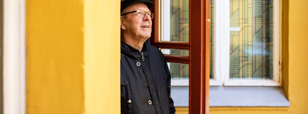 Eläkeläinen avaa oven. Pensionär öpnar dörren.