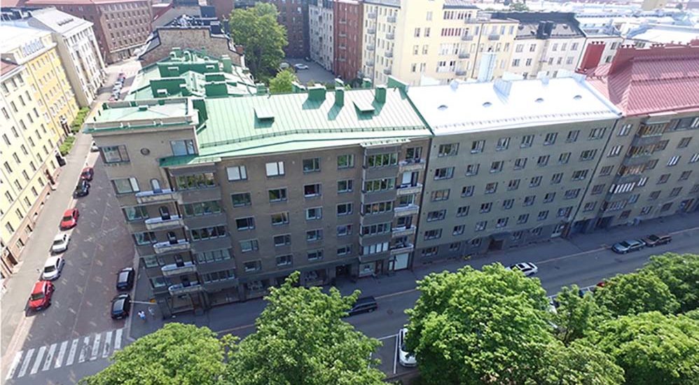 Flygfoto av Hesperiagatans flervåningshus. Andra flervåningshus och bilar syns också på bilden.
