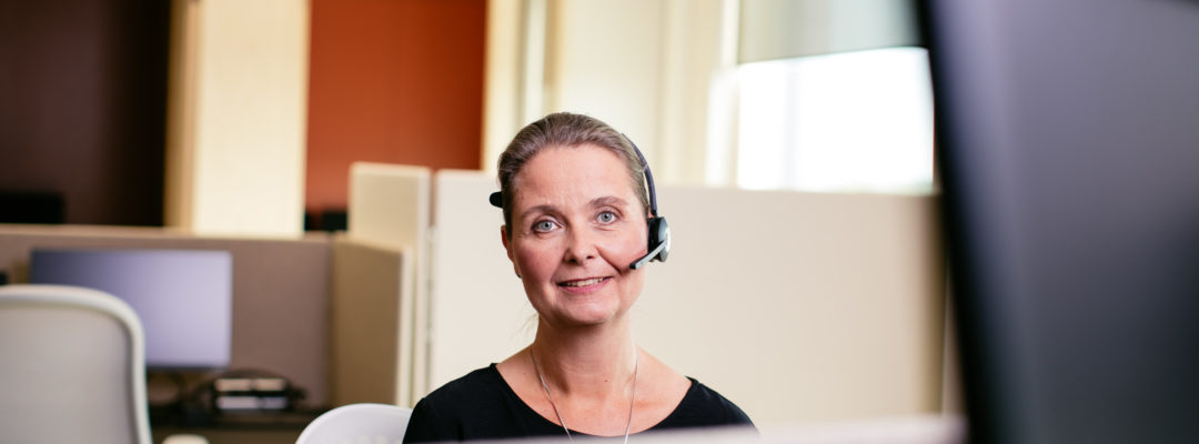 Rådgivaren Clarice betjänar kunden i telefon med hörlurar.