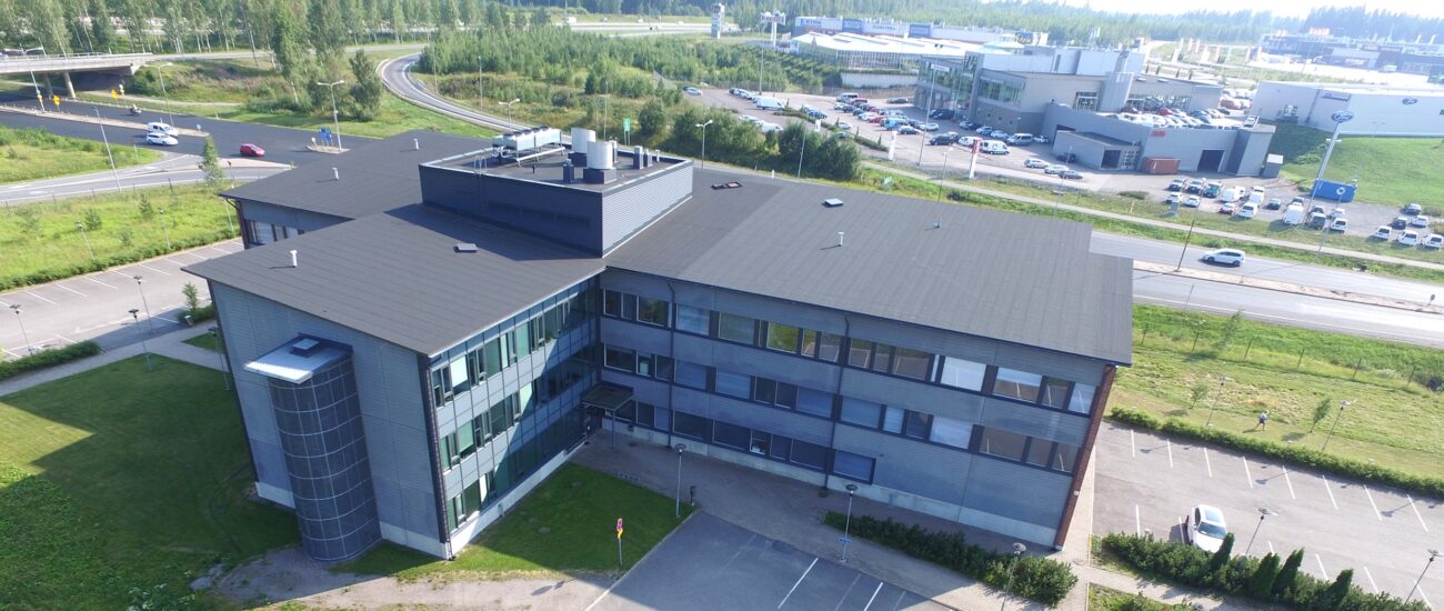 Porvoon tekniikankaaren kiinteistö kuvattuna sisäpihalta, jossa on paljon parkkipaikkoja.