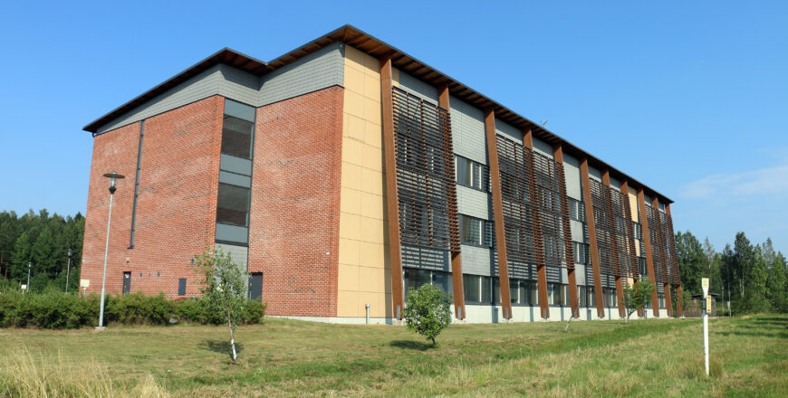 Porvoon tekniikankaaren kolmikerroksinen kiinteistö kuvattuna vihreältä nurmialueelta.