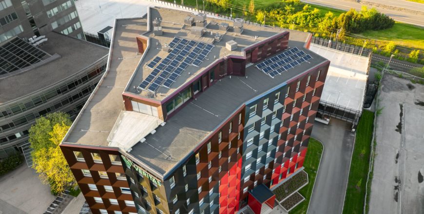 Aerial picture of the colourful Veritas headquarters building Retoriikka. There are dozens of solar panels on its roof.
