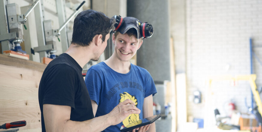 Men are talking in front of a pile af wood.