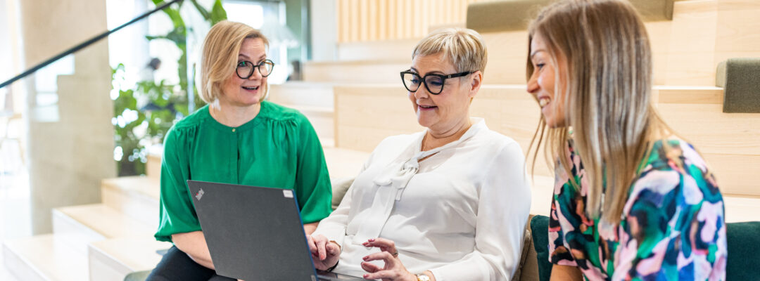 Tree anställda sitter vid datorn på huvudkontoret i Åbo.